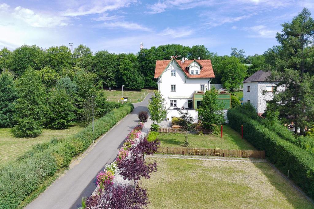 une maison blanche avec un jardin et une allée. dans l'établissement Hotel U Parku, à Hořovice