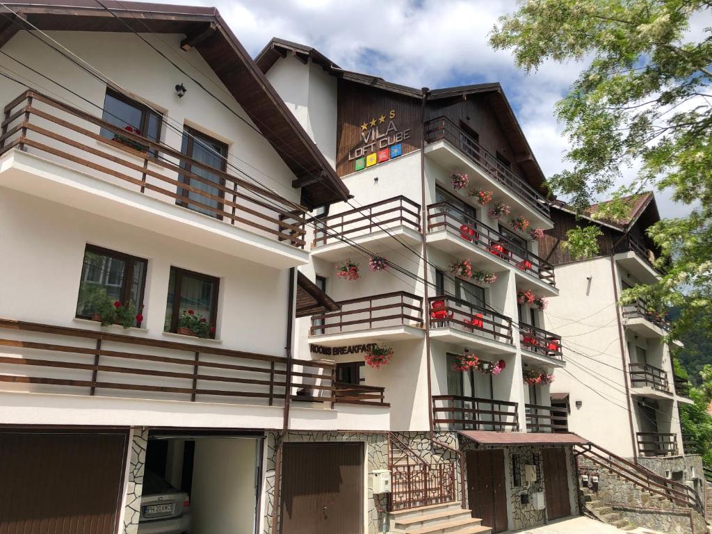 a house with balconies and flowers in front of it at Vila LOFT CUBE in Sinaia