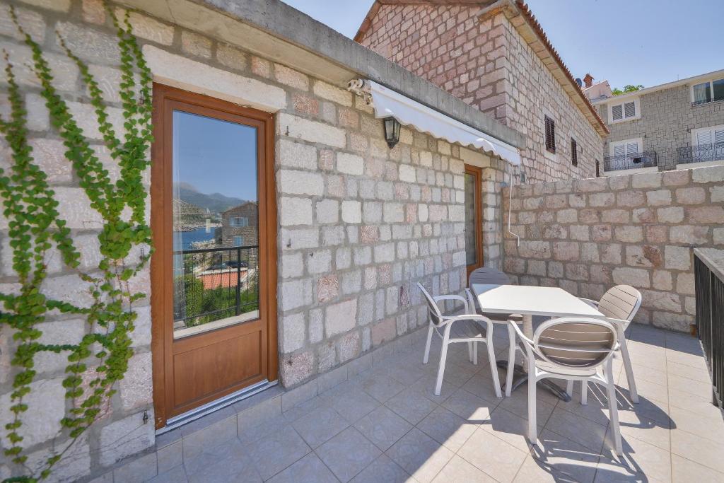 a patio with a table and chairs and a window at Kazanegra Exclusive Apartments in Sveti Stefan
