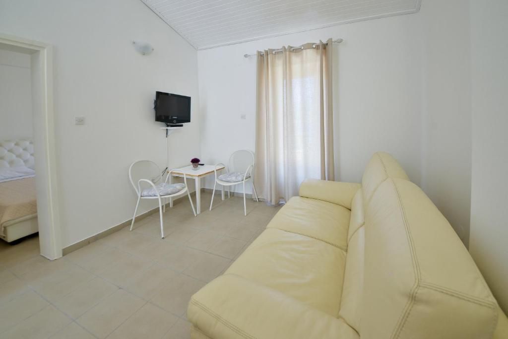 a living room with a white couch and a table at Kazanegra Exclusive Apartments in Sveti Stefan