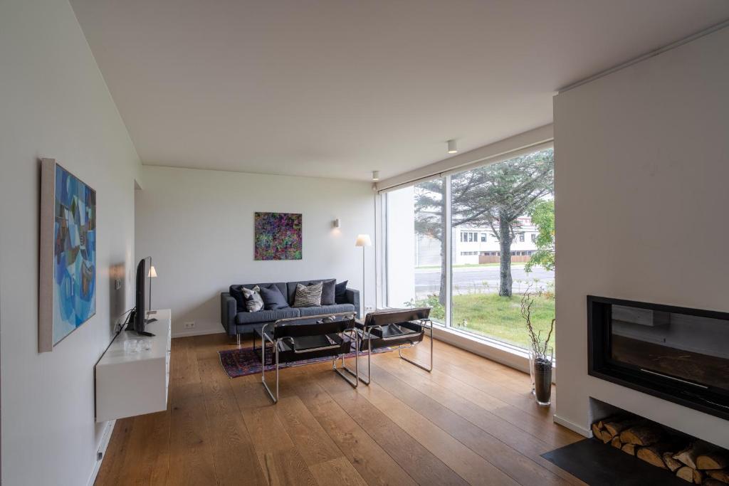 uma sala de estar com um sofá e uma lareira em Stylish and Spacious Family Home em Reiquiavique
