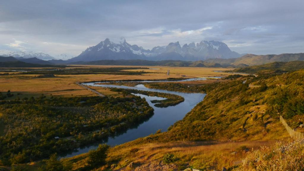 an aerial view of a river with mountains in the background at Departamentos 8va Maravilla in Torres del Paine