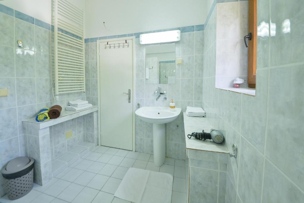 a white bathroom with a sink and a shower at Kazanegra Exclusive Apartments in Sveti Stefan