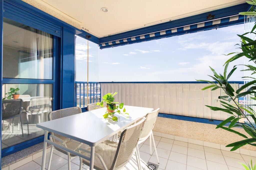 balcón con mesa y sillas y ventana grande en Patacona Breeze, en Valencia