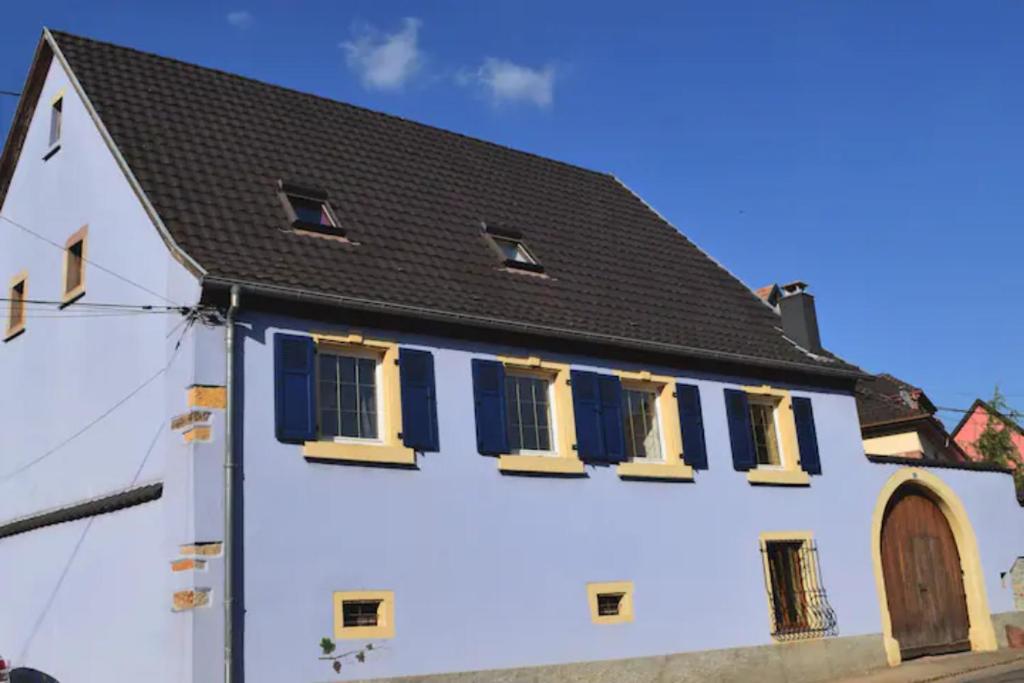 Casa blanca con persianas azules y techo negro en Les terrasses du Zinnkoepflé (8 à 12 personnes), en Westhalten