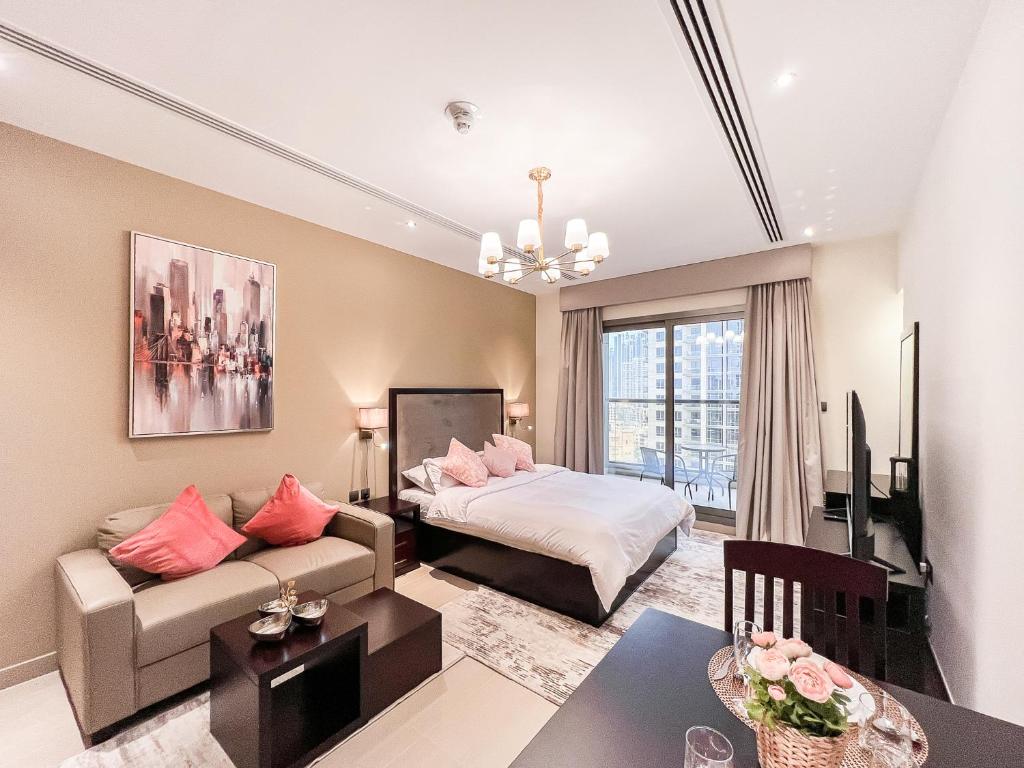 uma sala de estar com um sofá e uma cama em Luton Vacation Homes - Elite Residence Downtown, Burj Khalifa View, Dubai em Dubai