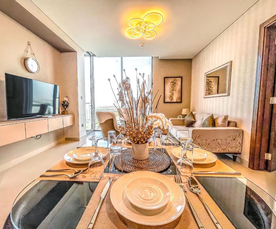 a dining room with a table and a tv at STAY BY LATINEM Luxury 2BR Holiday Home CV B1309 Near Burj Khalifa in Dubai