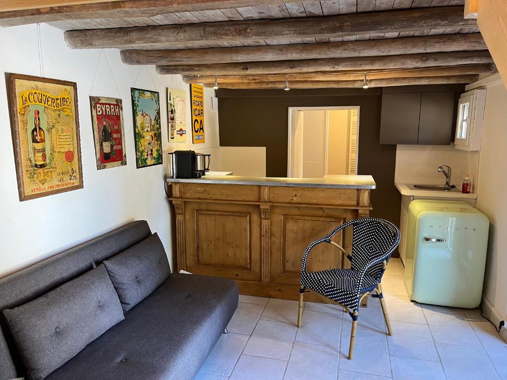 een woonkamer met een bank en een keuken bij Le Hameau du Buron - "La Taverne" - Option SPA in Eyzin-Pinet