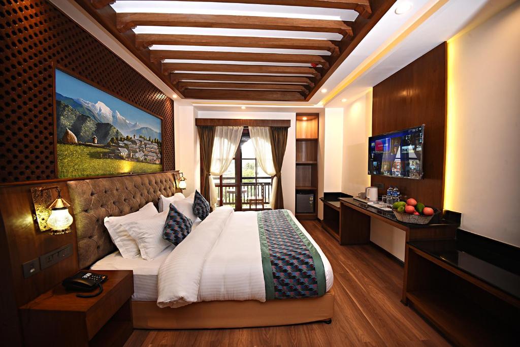 a bedroom with a large bed and a television at Everest Boutique Hotel in Kathmandu
