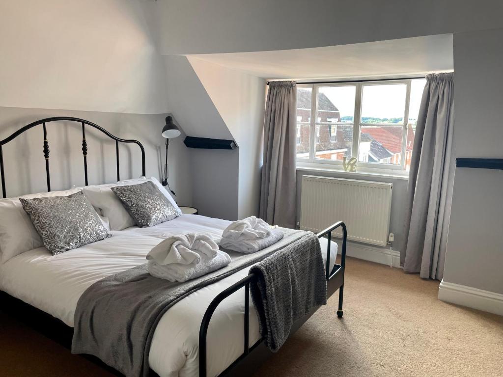 a bedroom with a bed and a large window at Elizabeth Clark in Manningtree