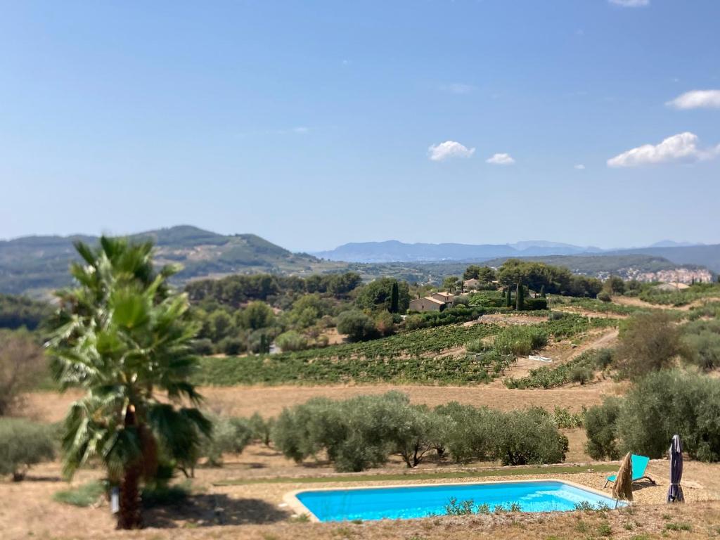 une piscine au milieu d'un champ avec des arbres dans l'établissement La Venturonne Appartement neuf Rez de jardin 45 m2 vue mer et vignes 10 mn des plages, au Beausset