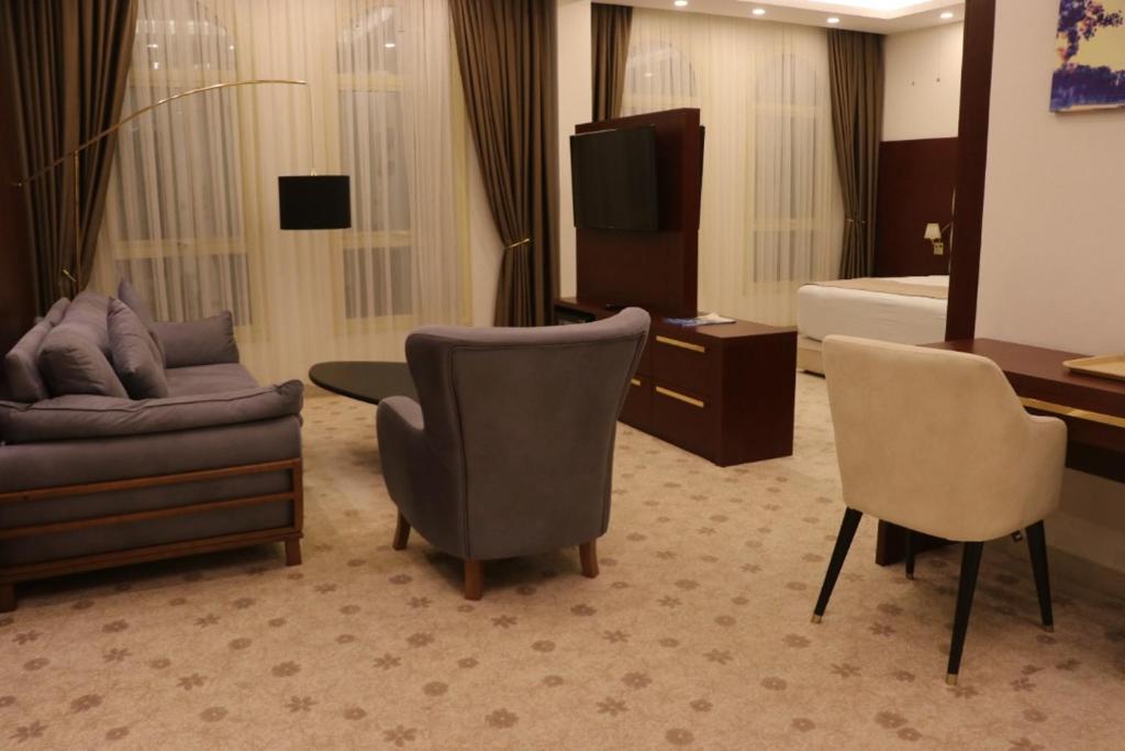 ジブチにあるGolden Airport Hotelのソファ、椅子、ベッドが備わるホテルルームです。