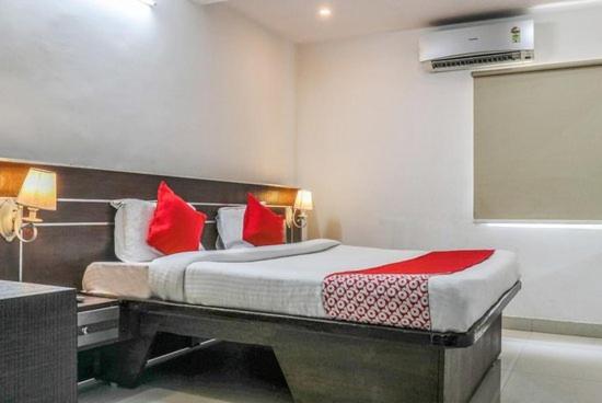 1 dormitorio con 1 cama grande con almohadas rojas en The Padmavathi Guest House - Vizag, en Visakhapatnam