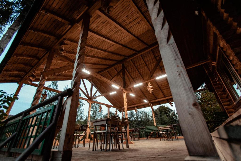 a large wooden pavilion with tables and stools at Cabana La Panţiru in Văleni-Stînişoara