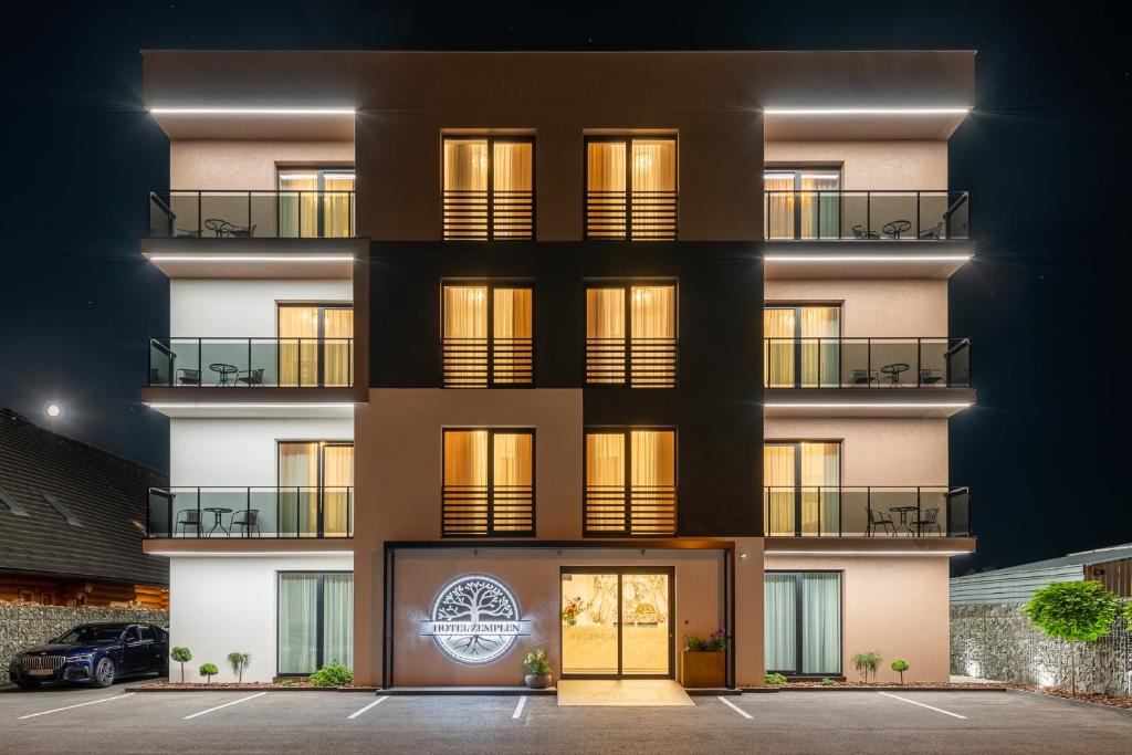 um edifício de apartamentos à noite com as luzes acesas em Hotel ZEMPLEN em Michalovce