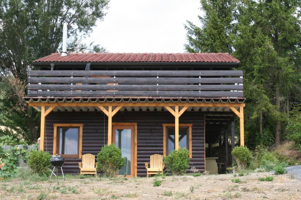 a log cabin with two chairs and a roof at Holzhaus Fechheim in Neustadt bei Coburg