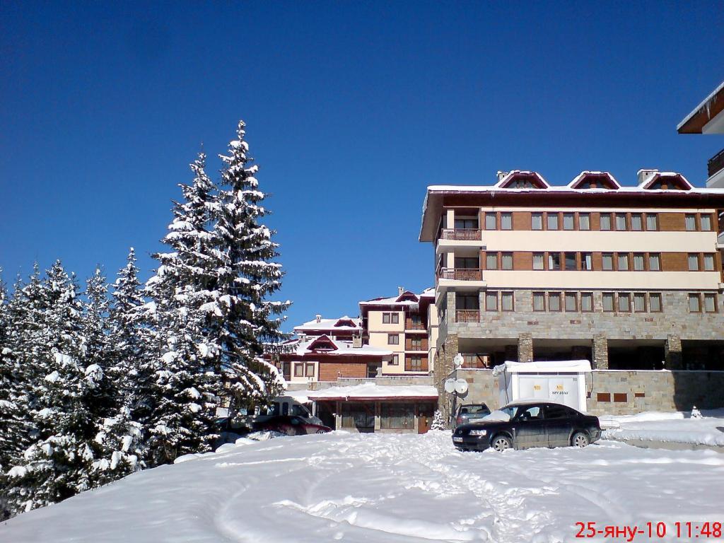 a car parked in front of a building in the snow at Deluxe Room in Stoykite in Pamporovo