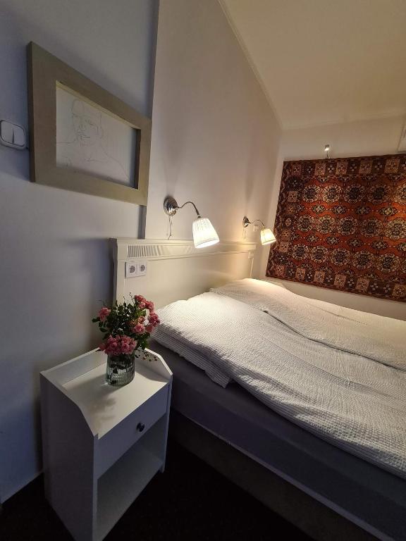 A bed or beds in a room at Palantír Panzió