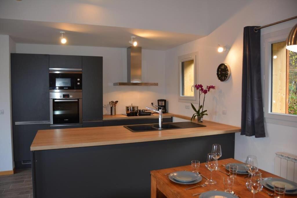 - une cuisine avec un comptoir, un évier et une cuisinière dans l'établissement Chalet Alexanne - Meublé de tourisme classé 3 étoiles - Porte de St Gervais, à Passy