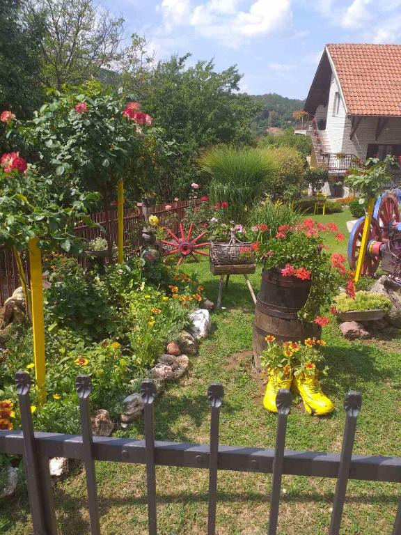 a garden with flowers in a yard with a fence at Apartmani Mali Raj Rudnik in Rudnik