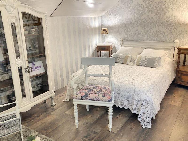 ein Schlafzimmer mit einem weißen Bett und einem Stuhl in der Unterkunft VILLA NOTRE DAME face au Château fort in Sedan