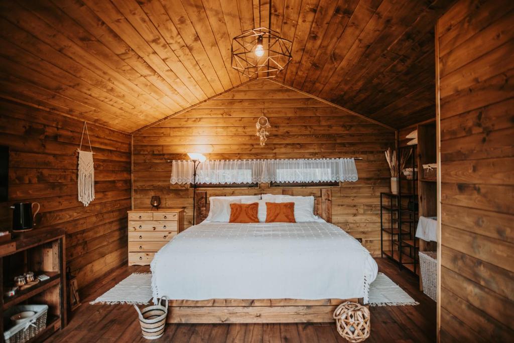 1 dormitorio con 1 cama en una cabaña de madera en Romantické ubytovanie pre dvoch v lese, en Banská Bystrica