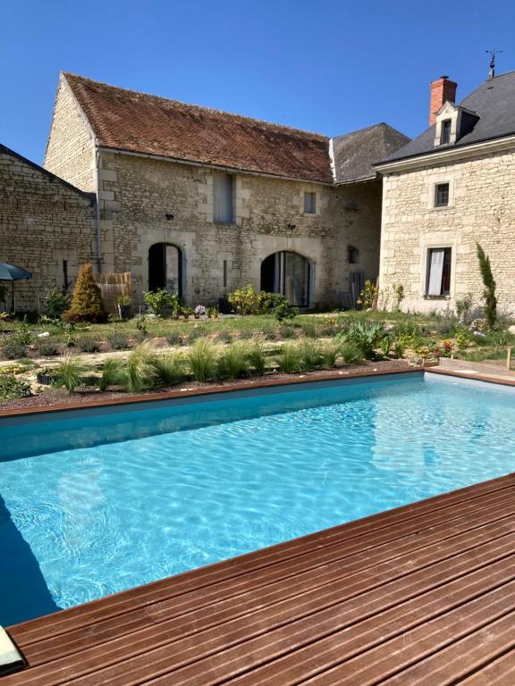 a swimming pool in front of a house at Le Manoir des Sables - Chambre familiale grand confort in Berthegon