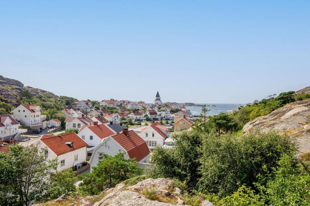 un pueblo en una colina con el océano en el fondo en Family home near the ocean, with large patio & BBQ en Skärhamn