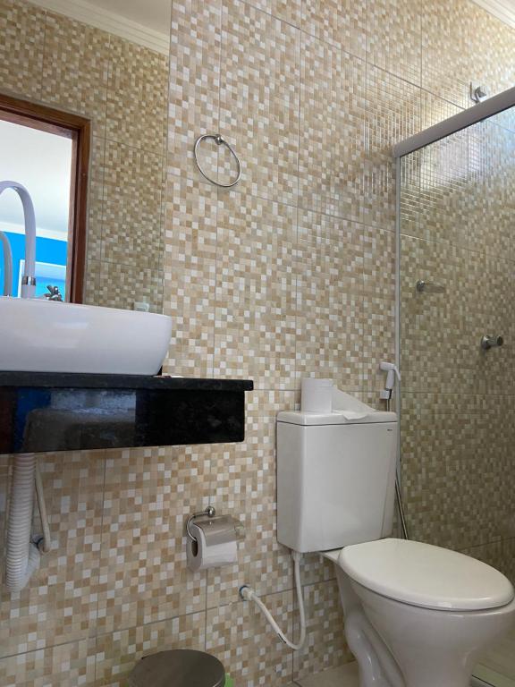 a bathroom with a toilet and a sink and a shower at Pousada Villa Costeira in Maragogi