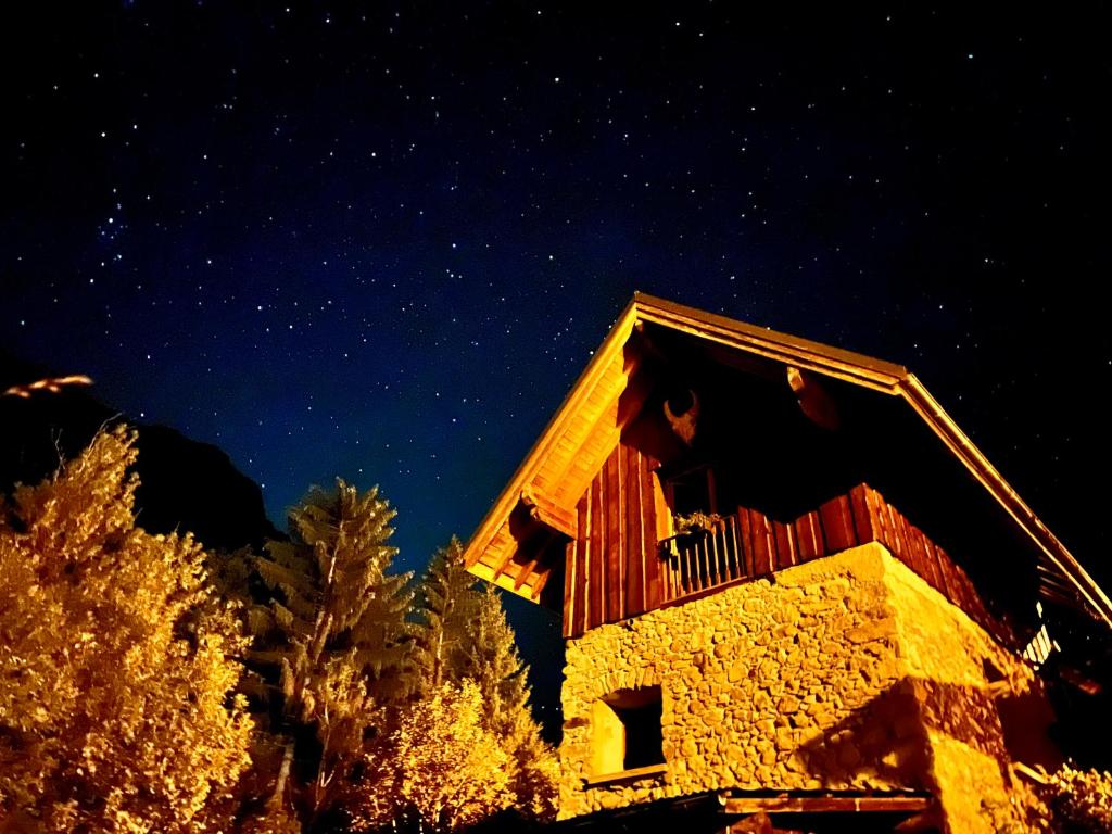um edifício à noite com as estrelas no céu em Ecrins Lodge em Le Bourg-dʼOisans
