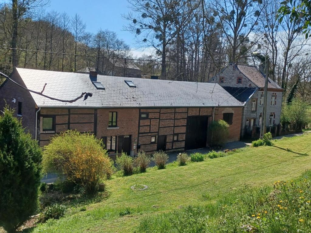 una gran casa de ladrillo con techo de gambrel en La Ferme du Couchant, en Beauraing