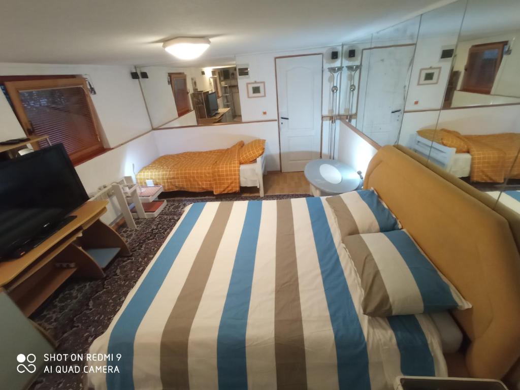 um pequeno quarto com uma cama, uma secretária e um quarto em Bolero apartman em Sarajevo