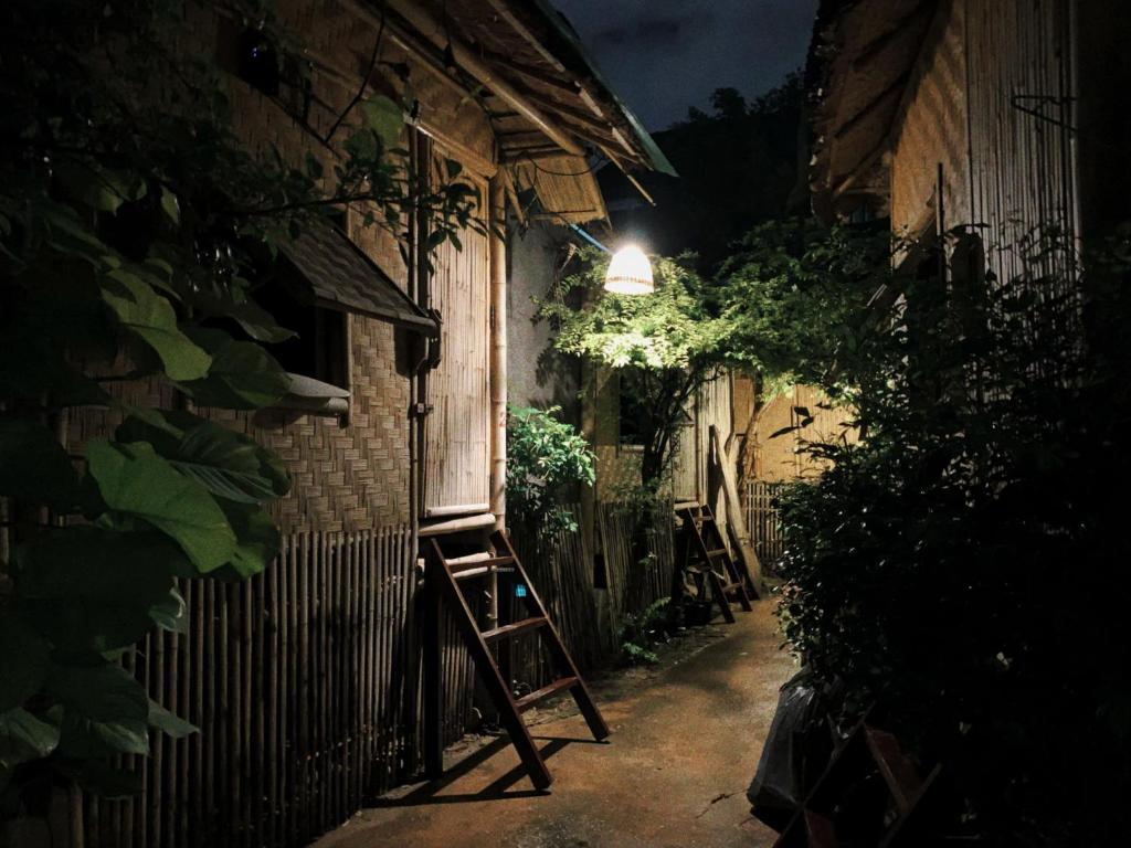 a ladder leaning against a building at night at Fundee Story Guesthouse Bamboo House in Chiang mai old town in Chiang Mai