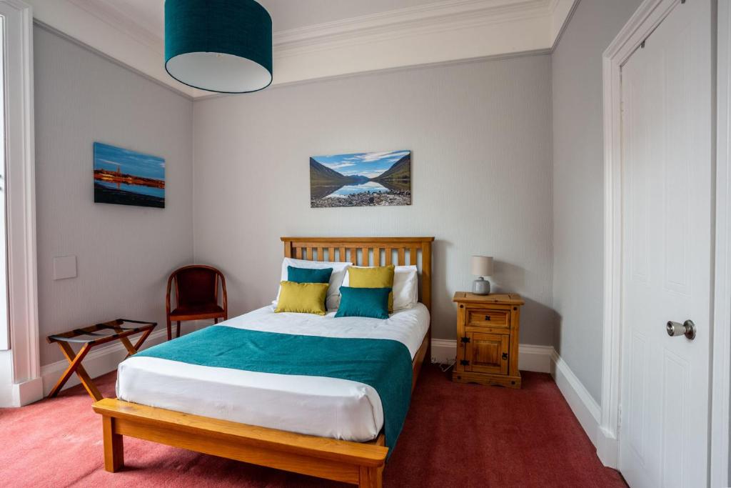 - une chambre avec un lit doté d'oreillers bleus et jaunes dans l'établissement The Juniper Rooms, à Montrose