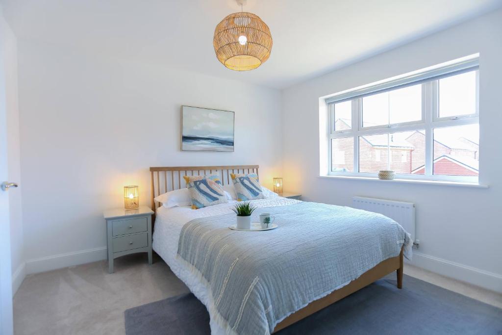 um quarto branco com uma cama grande e uma janela em 'Elements' 3 bed home in Bracklesham Bay em Chichester