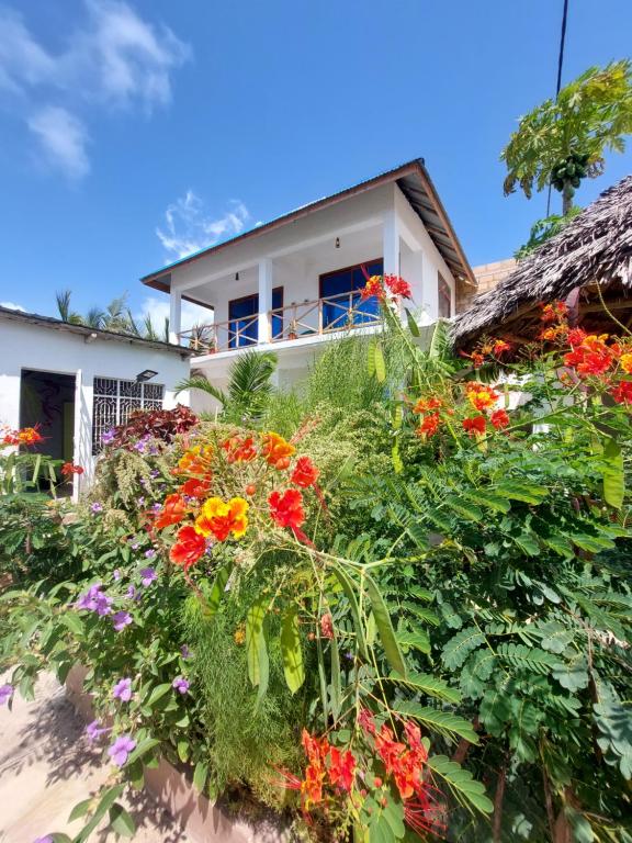 una casa con flores delante en Karibu House, en Paje