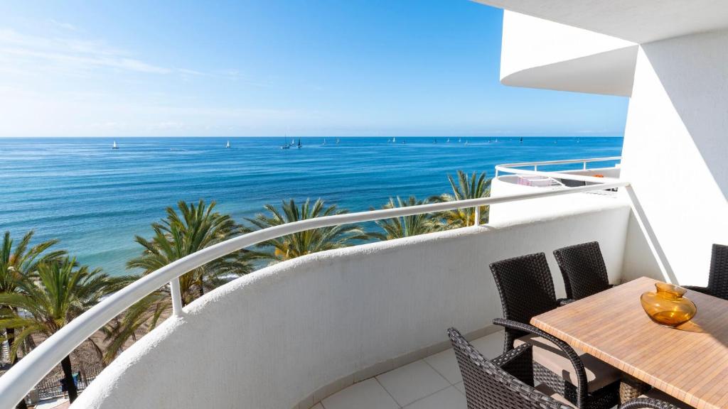 a balcony with a table and chairs and the ocean at Hapimag Apartments Marbella in Marbella