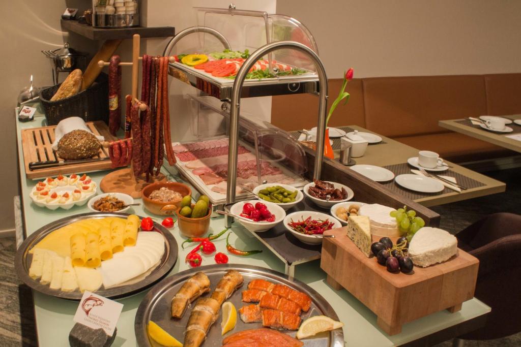 a table topped with lots of different types of food at Villa Pica Paca - Old Town in Gdańsk