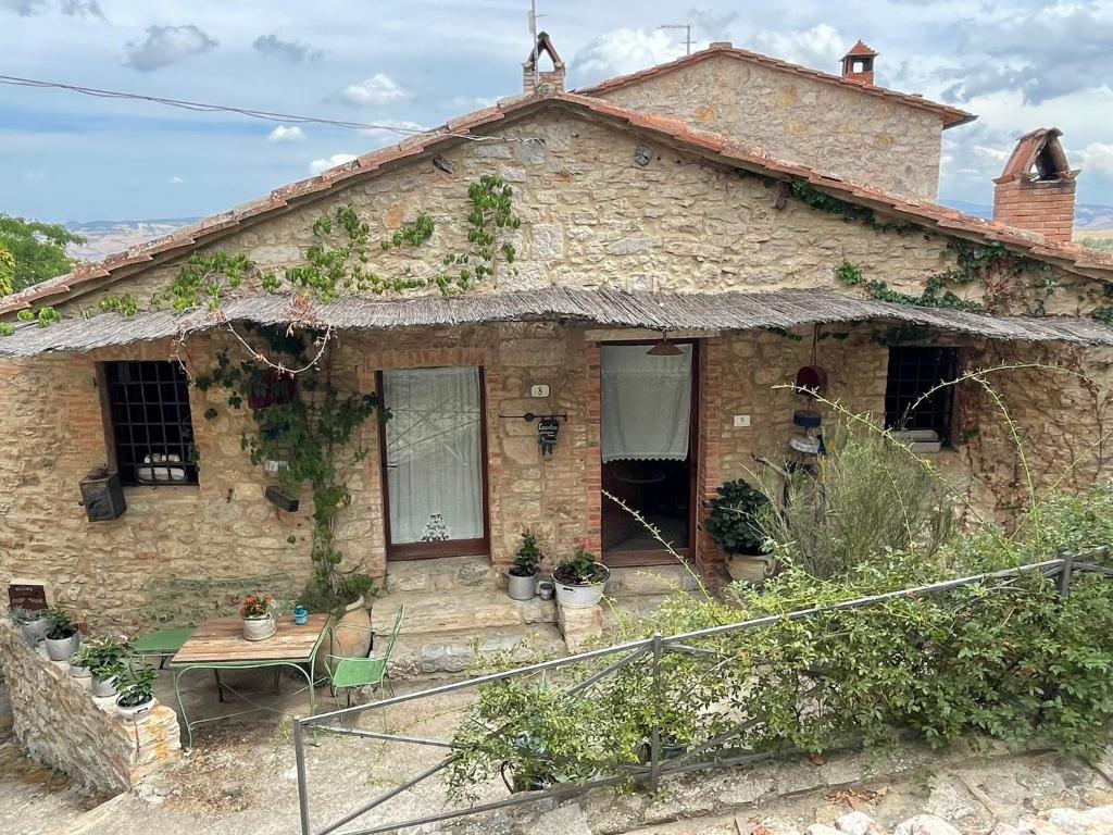 an old stone house with a table in front of it at Casa Antica in Castiglione dʼOrcia