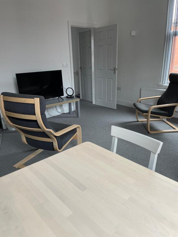 una camera con due sedie, un tavolo e una TV di Modern,spacious 2 bed apartment a Preston