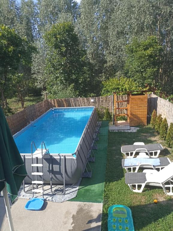 a swimming pool with a bunch of chairs around it at Vikendica apartments Dunav MS in Čelarevo