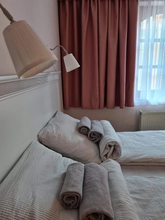 A bed or beds in a room at Palantír Panzió