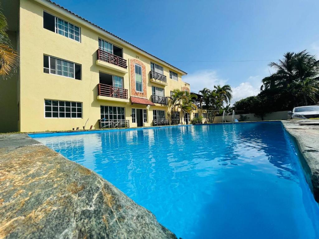 a swimming pool in front of a building at Lovely 2 Bedroom Condo With Pool And Hot Water in Cabarete