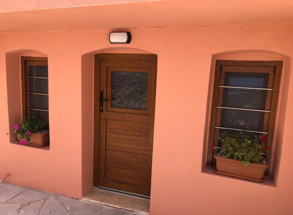a front door of a house with two windows at Solo traveler in Ermoupoli