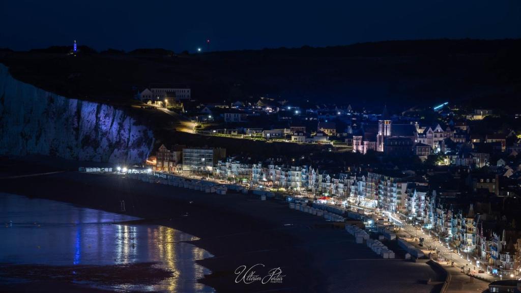 a city at night with lights on the beach at Studio Lilouna avec parking privé in Le Tréport
