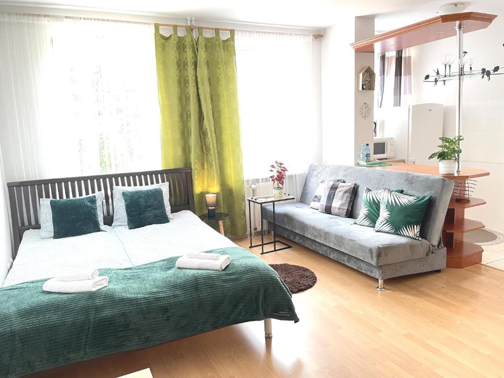 a bedroom with a bed and a couch at Studio przy Starówce in Olsztyn