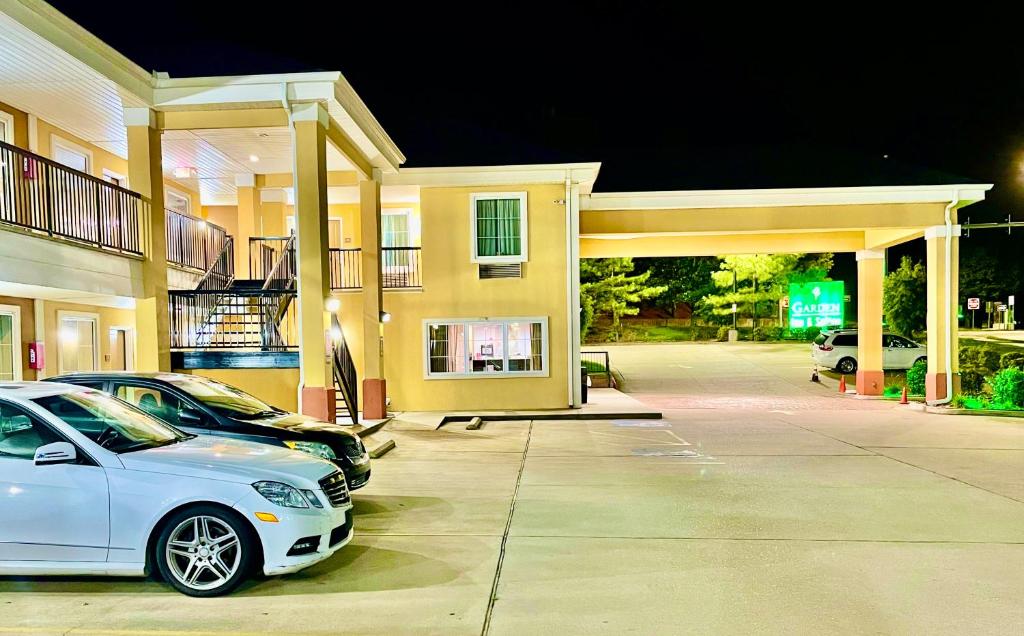 um carro branco estacionado em frente a um edifício em Garden Inn and Suites em Little Rock