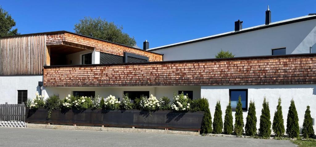 un bâtiment en briques avec des fleurs blanches devant lui dans l'établissement Dahoam by Tani, à Oberndorf en Tyrol