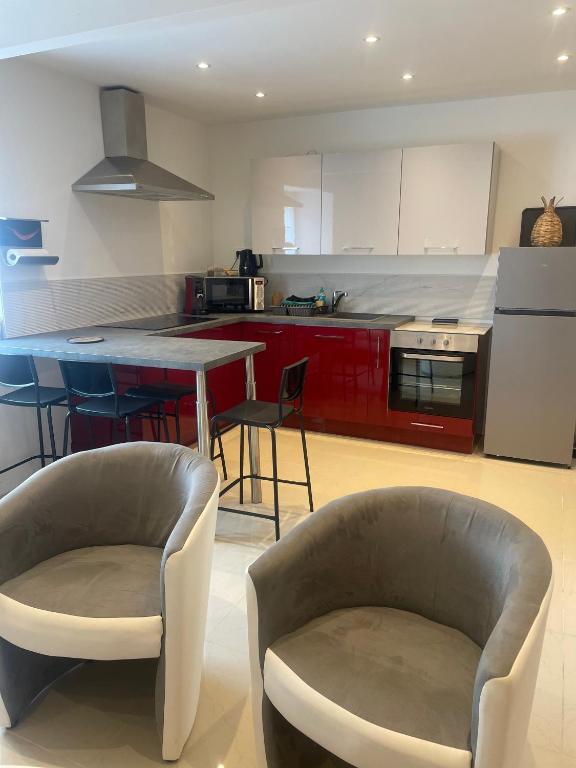 a kitchen with two chairs and a table in it at Duplex près de Nantes in Thouaré-sur-Loire