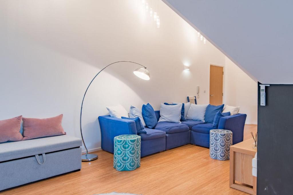 a living room with a blue couch and a table at The Loft at Emperor Court by Bloom Stays in Canterbury